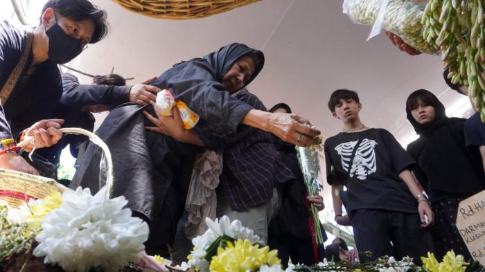 Ernawati didampingi anak dan cucunya menaburkan bunga ke pusara makam suaminya Darmawan Kusumawardhana Hardjakusumah alias Acil Bimbo yang baru saja dimakamkan di TPU Cipageran, Kota Cimahi, Jawa Barat, Selasa (2/9/2025).