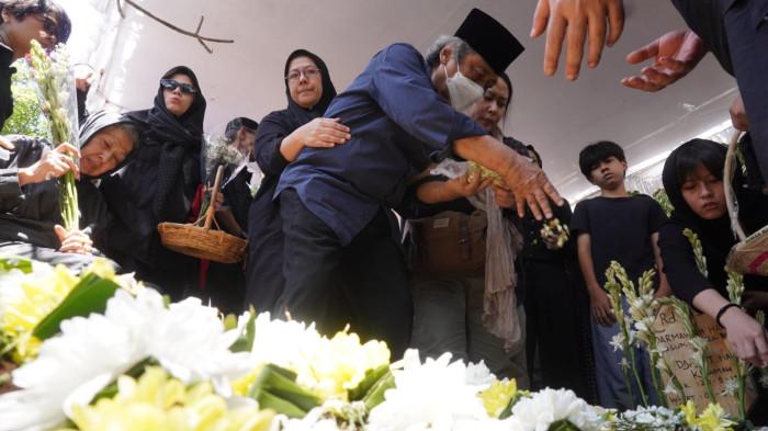 Sam Bimbo menaburkan bunga ke pusara makam saudaranya Darmawan Kusumawardhana Hardjakusumah alias Acil Bimbo yang baru saja dimakamkan di TPU Cipageran, Kota Cimahi, Jawa Barat, Selasa (2/9/2025).