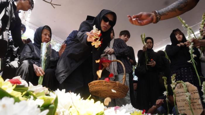 Keluarga menaburkan bunga ke pusara makam Darmawan Kusumawardhana Hardjakusumah alias Acil Bimbo yang baru saja dimakamkan di TPU Cipageran, Kota Cimahi, Jawa Barat, Selasa (2/9/2025).