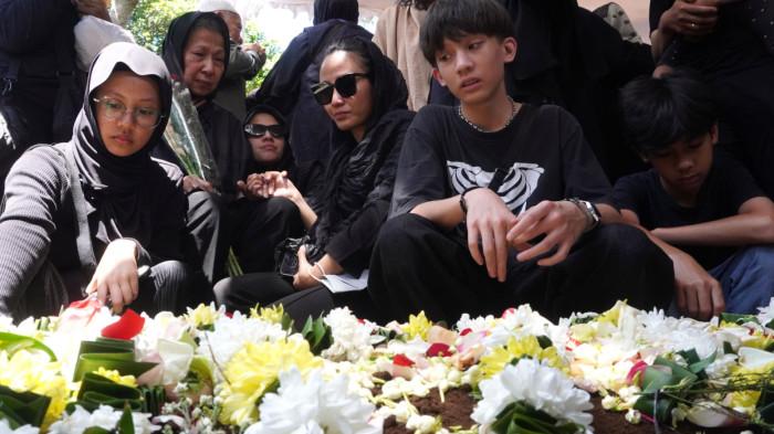 Ernawati didampingi sejumlah cucunya, dengan wajah sedih menatap ke arah pusara makam suaminya Darmawan Kusumawardhana Hardjakusumah alias Acil Bimbo yang baru saja dimakamkan di TPU Cipageran, Kota Cimahi, Jawa Barat, Selasa (2/9/2025).