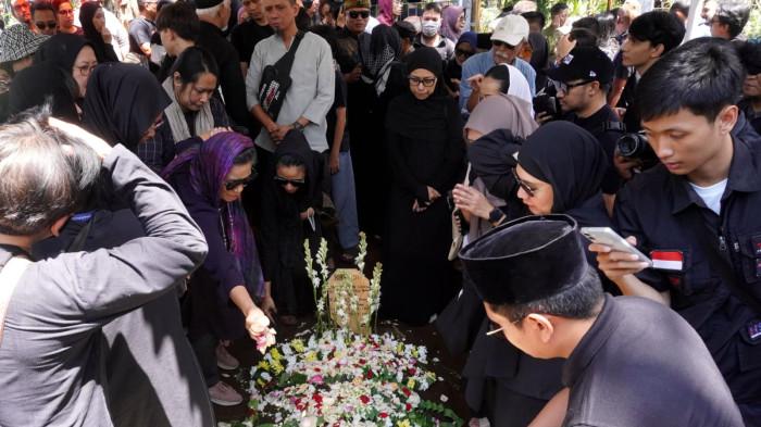Keluarga, kerabat, dan pelayat menabur bunga ke pusara makam Darmawan Kusumawardhana Hardjakusumah alias Acil Bimbo yang baru saja dimakamkan di TPU Cipageran, Kota Cimahi, Jawa Barat, Selasa (2/9/2025).