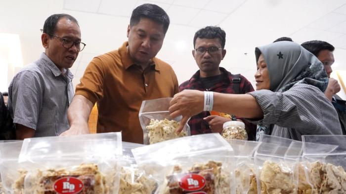 Menteri Perumahan dan Kawasan Permukiman (PKP), Maruara Sirait mengunjungi dan berbelanja cemilan yang dijajakan pelaku UMKM seusai menghadiri acara Sosialisasi Kredit Program Perumahan untuk UMKM di salah satu kampus di Kota Bandung, Jawa Barat, Sabtu (20/9/2025).
