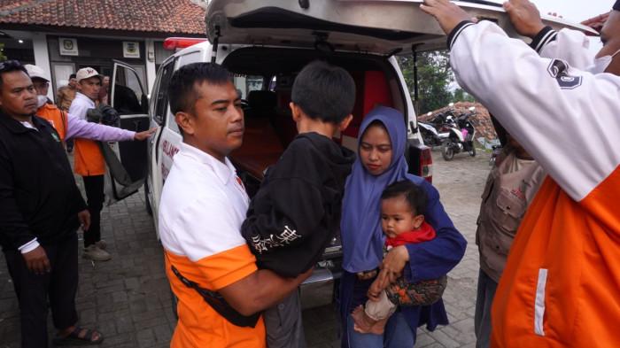 Petugas membawa seorang pelajar dan ibunya diduga keracunan Makanan Bergizi Gratis (MBG) saat tiba di Posko Penanganan Kantor Kecamatan Cipongkor, Kabupaten Bandung Barat, Jawa Barat, Kamis (25/9/2025).