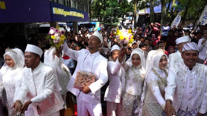 Pasang pengantin yang sudah melangsungkan akad nikah melempar bunga kepada kerumunan warga dalam gelaran Nikah Gratis di Mal Pelayanan Publik (MPP) Kota Bandung,  Jalan Sukabumi, Kota Bandung, Jawa Barat, Jumat (26/9/2025).