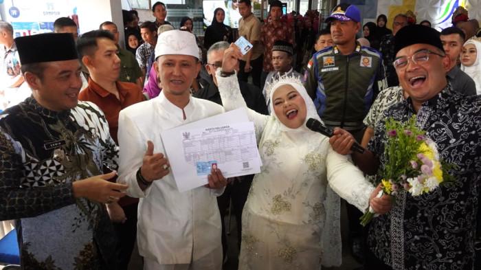 Wali Kota Bandung, M Farhan dan Wakil Wali Kota Bandung, Erwin menyerahkan Kartu Keluarga (KK) kepada salah satu pasang pengantin yang sudah akad nikah dalam gelaran Nikah Gratis di Mal Pelayanan Publik (MPP) Kota Bandung,  Jalan Sukabumi, Kota Bandung, Jawa Barat, Jumat (26/9/2025).