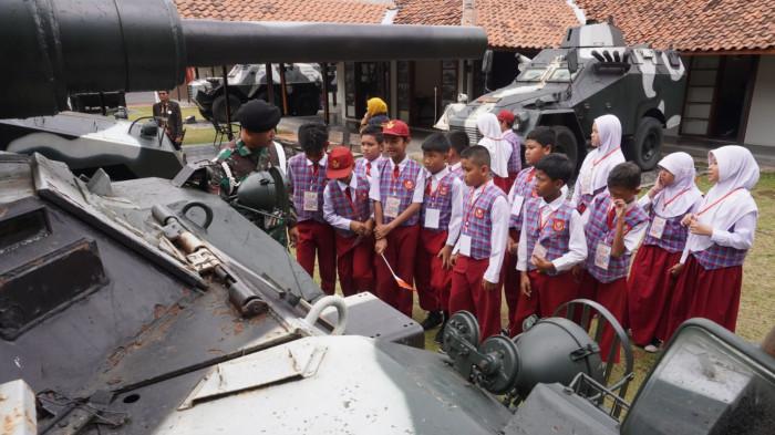 Sejumlah pelajar SD menyimak keterangan yang disampaikan petugas seputar kendaraan tempur yang sedang dilihatnya saat study tour di Museum Kavaleri TNI Angkatan Darat, Jalan Gatot Subroto, Kota Bandung, Jawa Barat, Selasa (30/9/2025).