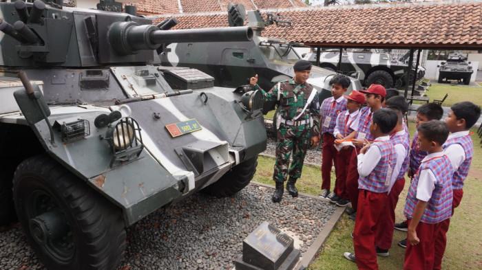 Sejumlah pelajar SD menyimak keterangan yang disampaikan petugas seputar kendaraan tempur yang sedang dilihatnya saat study tour di Museum Kavaleri TNI Angkatan Darat, Jalan Gatot Subroto, Kota Bandung, Jawa Barat, Selasa (30/9/2025).