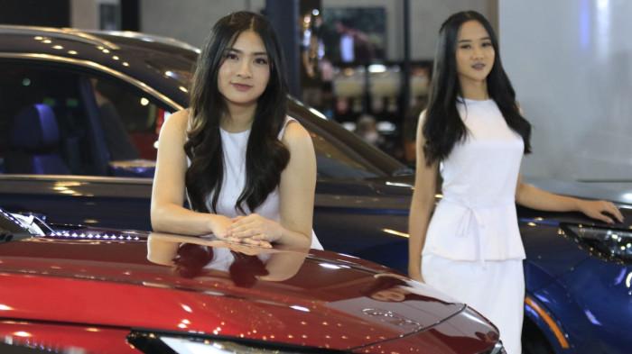 Usher wanita berpose di samping kendaraan bermotor pada pameran otomotif Gaikindo Indonesia International Auto Show (GIIAS) Bandung 2025 di Sudirman Grand Ballroom, Kota Bandung, Jawa Barat, Kamis (2/10/2025).