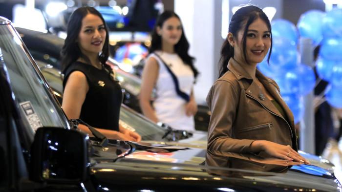 Usher wanita berpose di samping kendaraan bermotor pada pameran otomotif Gaikindo Indonesia International Auto Show (GIIAS) Bandung 2025 di Sudirman Grand Ballroom, Kota Bandung, Jawa Barat, Kamis (2/10/2025).