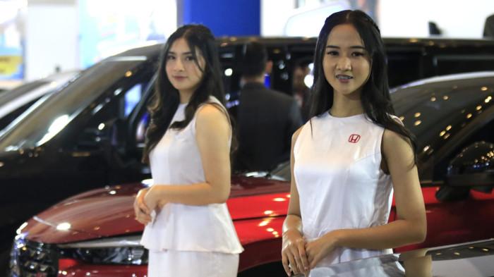 Usher wanita berpose di samping kendaraan bermotor pada pameran otomotif Gaikindo Indonesia International Auto Show (GIIAS) Bandung 2025 di Sudirman Grand Ballroom, Kota Bandung, Jawa Barat, Kamis (2/10/2025).