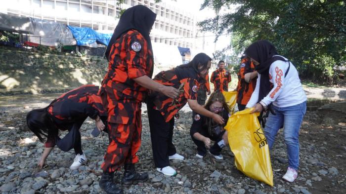 Sejumlah anggota Pemuda Pancasila (PP) Kota Bandung memungut sampah di aliran Sungai Cikapundung, Kota Bandung, Jawa Barat, Selasa (7/10/2025).