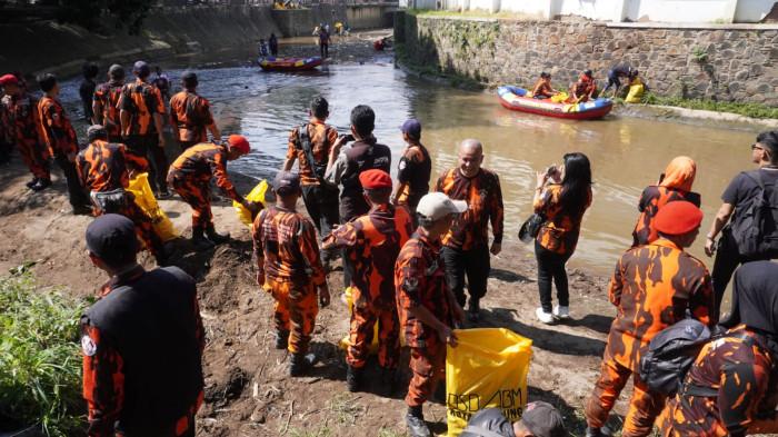 Sejumlah anggota Pemuda Pancasila (PP) Kota Bandung memungut sampah dan mencabut rumput liar di aliran Sungai Cikapundung, Kota Bandung, Jawa Barat, Selasa (7/10/2025).