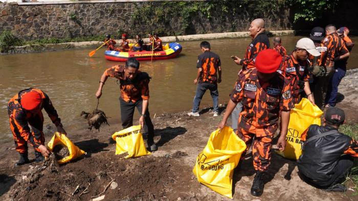 Sejumlah anggota Pemuda Pancasila (PP) Kota Bandung memungut sampah di aliran Sungai Cikapundung, Kota Bandung, Jawa Barat, Selasa (7/10/2025).