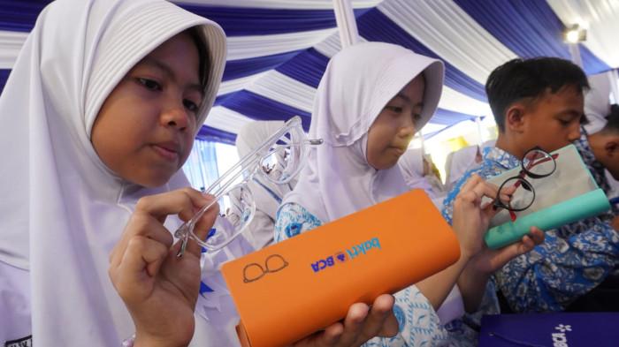 Sejumlah pelajar melihat kacamata yang baru diterimanya pada penutupan kegiatan 