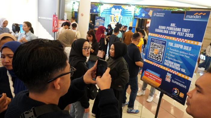 Penonton melakukan registrasi saat akan menyaksikan festival musik Suara Loka Livin Fest Bandung 2025 di Trans Convention Center, KOta Bandung, Jawa Barat, Minggu (26/10/2025).