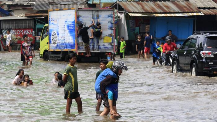 Pengguna jalan melintasi banjir yang merendam Jalan Raya Dayeuhkolot, di Kecamatan Dayeuhkolot, Kabupaten Bandung, Jawa Barat, Senin (3/11/2025).