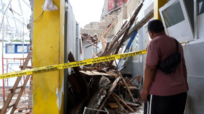 Seorang pekerja bangunan melihat atap bangunan ruang kelas yang ambruk di SMP Pasundan 1, Jalan Pasundan, Kelurahan Balonggede, Kota Bandung, Jawa Barat, Senin (3/11/2025).
