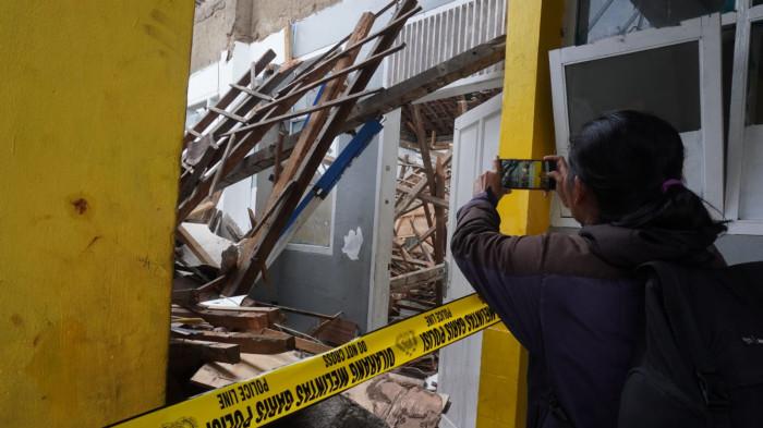 Seorang jurnalis mengambil gambar atap bangunan ruang kelas yang ambruk di SMP Pasundan 1, Jalan Pasundan, Kelurahan Balonggede, Kota Bandung, Jawa Barat, Senin (3/11/2025).