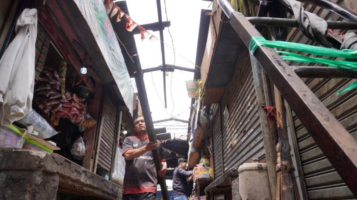 Pedagang memperbaiki atap jongkonya yang rusak akibat disapu angin puting beliung, di Pasar Ujungberung, Kota Bandung, Jawa Barat, Rabu (5/11/2025).