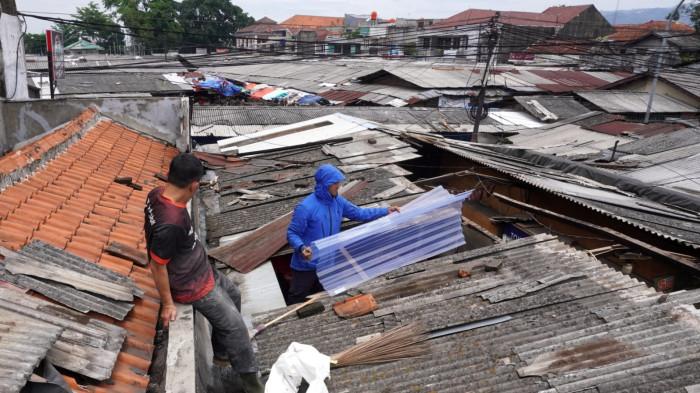 Pedagang memperbaiki atap jongkonya yang rusak akibat disapu angin puting beliung, di Pasar Ujungberung, Kota Bandung, Jawa Barat, Rabu (5/11/2025).