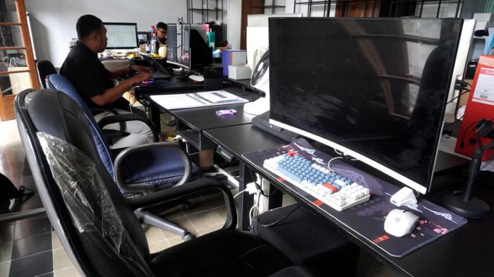 Dua orang aparatur sipil negara (ASN) menyelesaikan pekerjaan sementara sejumlah kursi lainnya tampak kosong dan lampu dipadamkan saat hari pertama penerapan work from home (WFH), di salah satu ruangan di Gedung Sate, Kota Bandung, Jawa Barat, Kamis (6/11/2025).