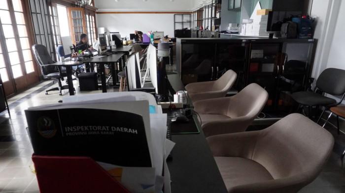 Dua orang aparatur sipil negara (ASN) menyelesaikan pekerjaan sementara sejumlah kursi lainnya tampak kosong dan lampu dipadamkan saat hari pertama penerapan work from home (WFH), di salah satu ruangan di Gedung Sate, Kota Bandung, Jawa Barat, Kamis (6/11/2025).