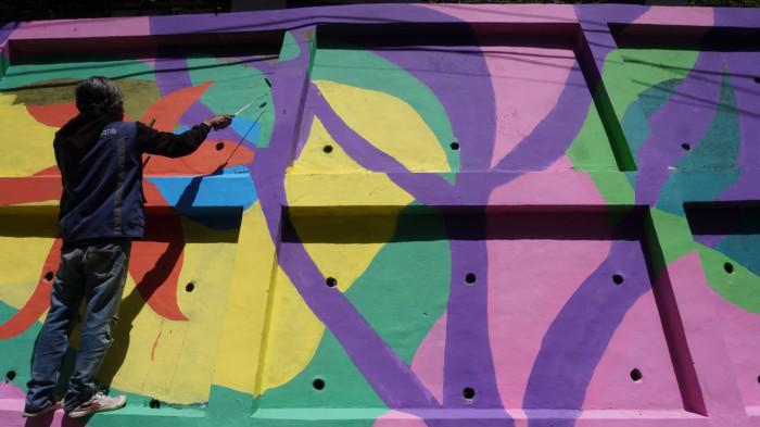 Petugas mengecat saat finishing pembuatan mural pada dinding tembok di kawasan Babakan Siliwangi, Jalan Siliwangi, Kota Bandung, Jawa Barat, Jumat (7/11/2025).
