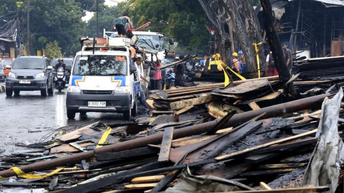 Sejumlah orang mengangkut atap seng yang masih bisa dipakai di antara puing sisa kebakaran jongko kayu di Jalan Terusan Pasirkoja, Kota Bandung, Jawa Barat, Rabu (12/11/2025).