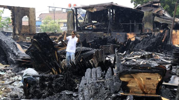 Warga mengais rejeki di antara puing sisa kebakaran jongko kayu di Jalan Terusan Pasirkoja, Kota Bandung, Jawa Barat, Rabu (12/11/2025).