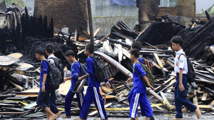 Pelajar melihat puing sisa kebakaran jongko kayu saat melintas di Jalan Terusan Pasirkoja, Kota Bandung, Jawa Barat, Rabu (12/11/2025).