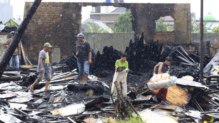 Warga mengais rejeki di antara puing sisa kebakaran jongko kayu di Jalan Terusan Pasirkoja, Kota Bandung, Jawa Barat, Rabu (12/11/2025).
