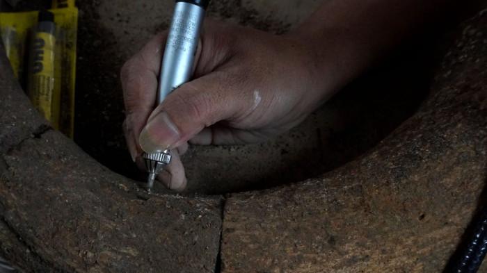 Preparator fosil melakukan preparasi perbersihan tanduk dari fosil banteng di ruang workshop Museum Geologi, Kota Bandung, Jawa Barat, Kamis (13/11/2025).