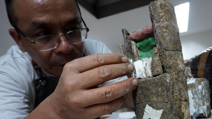Preparator fosil melakukan preparasi dan penyusunan bagian fosil gading yang peah di ruang workshop Museum Geologi, Kota Bandung, Jawa Barat, Kamis (13/11/2025).