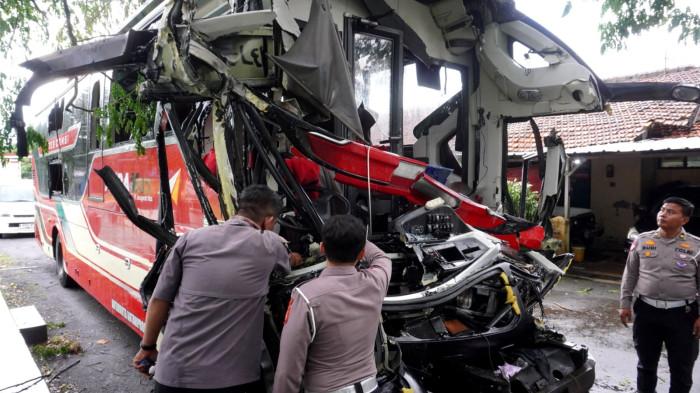 Pihak kepolisian memeriksa Bus PO Agra Mas yang kondisinya mengenaskan pasca tabrakan beruntun, di Polres Purwakarta, Kabupaten Purwakarta, Jawa Barat, Selasa (18/11/2025).