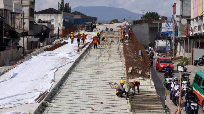 Sejumlah pekerja memasang besi beton untuk pengecoran badan jalan pada proyek pembangunan Flyover Nurtanio di Jalan Abdurahman Saleh - Garuda, Kota Bandung, Jawa Barat, Selasa (25/11/2025).