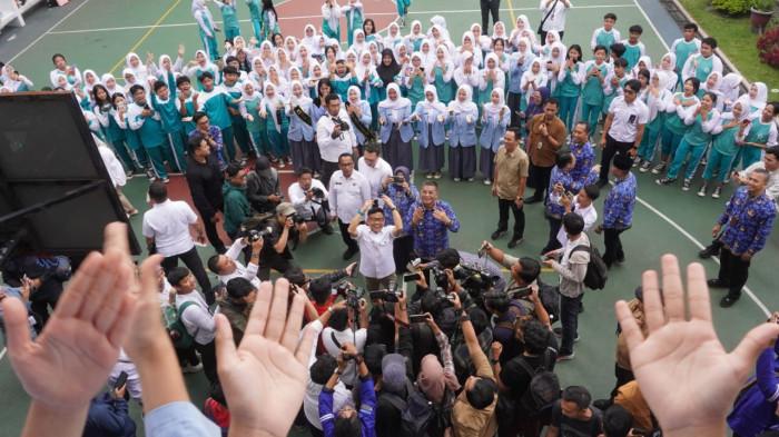 Menteri Koordinator Pemberdayaan Masyarakat (Menko PM), Muhaimin Iskandar, didampingi Wakil Gubernur Jawa Barat, Erwan Setiawan menyapa para pelajar saat kunjungan kerja dalam rangka Sosialisasi Program SMK Go Global, di SMKN 1 Bandung, Jalan Wastukencana, Kota Bandung, Jawa Barat, Senin (1/12/2025).