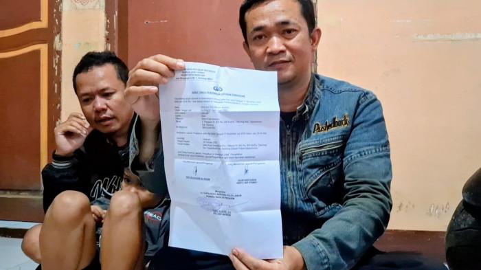 KORBAN TPPO - Ayahanda Riski Nur Fadhilah, Dedi Solehudin sedang memegang bukti laporan polisi. Fadhil diduga jadi korban TPPO di Kamboja