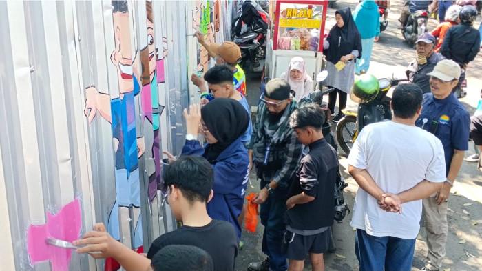 PENCIPTAAN KARYA MURAL  -  Tim PKM UNIKOM  Bersama dengan masyarakat mengerjakan mural di kawasan Pasar Cijerah Cerah