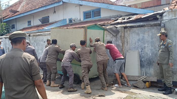 BONGKAR - Satpol PP saat membongkar lapak milik PKL di sekitar kawasan Stasiun Kejaksan, Kota Cirebon, Senin (10/11/2025) pagi.