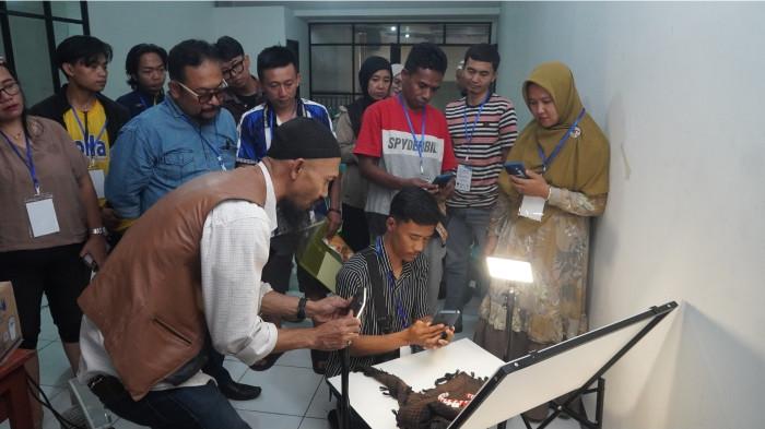 Ivan Kurniawan, M.Ds  memperagakan teknik fotografi produk dengan menggunakan handphone