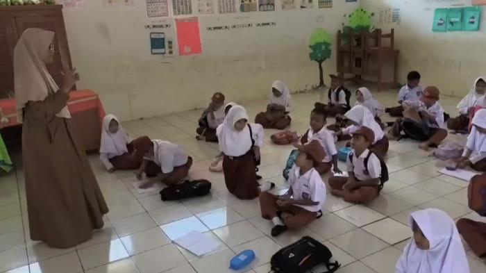 BELAJAR DI LANTAI - Murid Kelas 1 SDN Cibitung, Desa Pasirpanjang, Kecamatan Ciracap, Kabupaten Sukabumi, Jawa Barat, harus belajar telungkup di lantai karena tidak ada bangku.