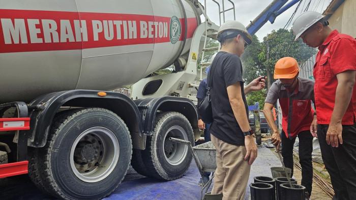 Pekerja mengawasi proyek pemasangan konstruksi beton