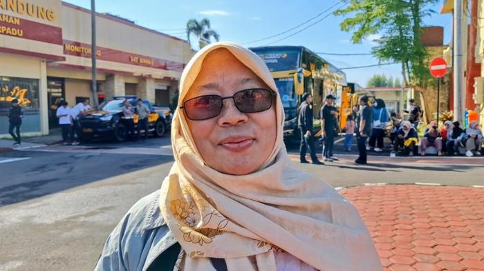 PESERTA MUDIK GRATIS - Sri Sekarningsih (54), saat mengikuti program mudik gratis Polresta Bandung.