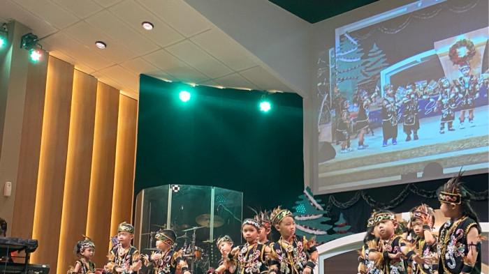 NATAL - Suasana sukacita memenuhi Gereja Utusan Pentakosta saat ratusan siswa dari TK LCC, SD Kasih Bangsa, dan Homeschooling Bintang Harapan merayakan Natal bersama, Jumat (12/12/2025).