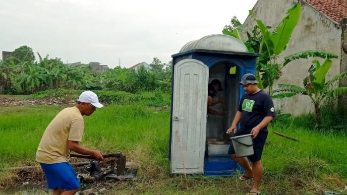 Sejumlah warga memasang WC portabel di lokasi banjir di Kompleks Griya Mitra, Cinunuk, Cileunyi, Kabupaten Bandung, Selasa (12/8/2025).