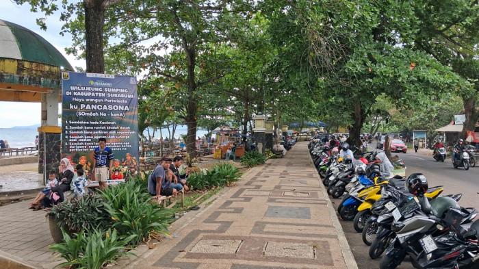 Kondisi parkiran di Pantai Citepus masih ramai wisatawan di H+5 libur Lebaran, cuan pedagang pun meningkat, Kamis (26/3/2026).