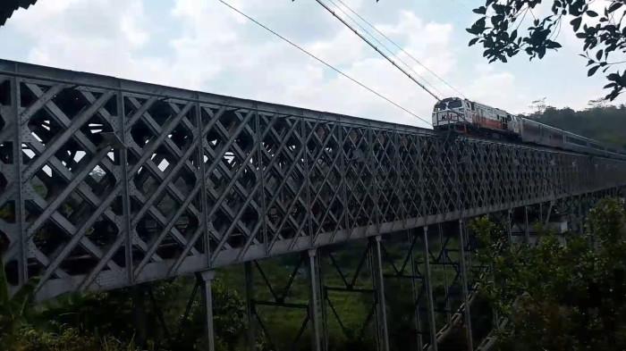 MELINTAS - Kereta Api Lodaya tengah melintas di atas jembatan Cirahong yang berada di perbatasan Kabupaten Tasikmalaya dengan Kabupaten Ciamis, Selasa (14/4/2026).
