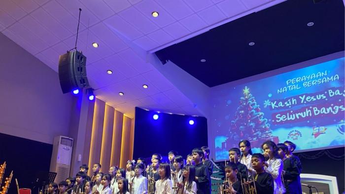NATAL - Suasana sukacita memenuhi Gereja Utusan Pentakosta saat ratusan siswa dari TK LCC, SD Kasih Bangsa, dan Homeschooling Bintang Harapan merayakan Natal bersama, Jumat (12/12/2025).