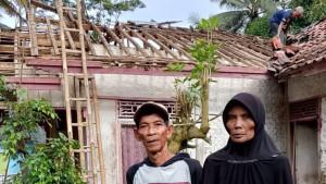 Hendar-dan-Maemunah-berdiri-di-depan-rumahnya-yang-sebagian-atapnya-ambruk.jpg