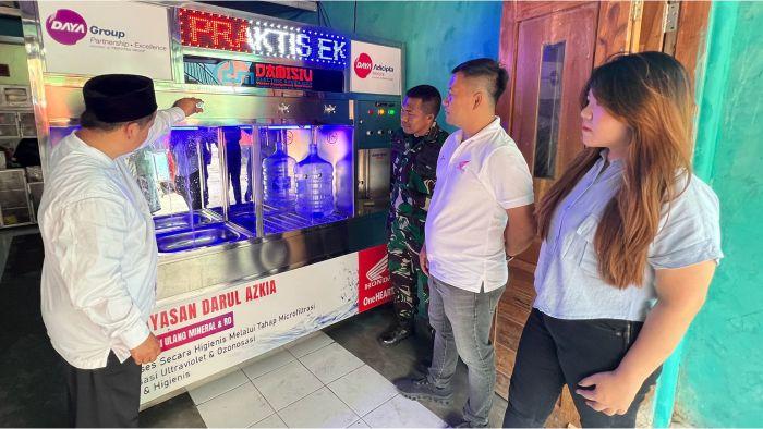 Ketua-Yayasan-Darul-Azkia-Saepuloh-SPdI-menunjukkan-cara-kerja-mesin-air-minum-isi-ulang.jpg